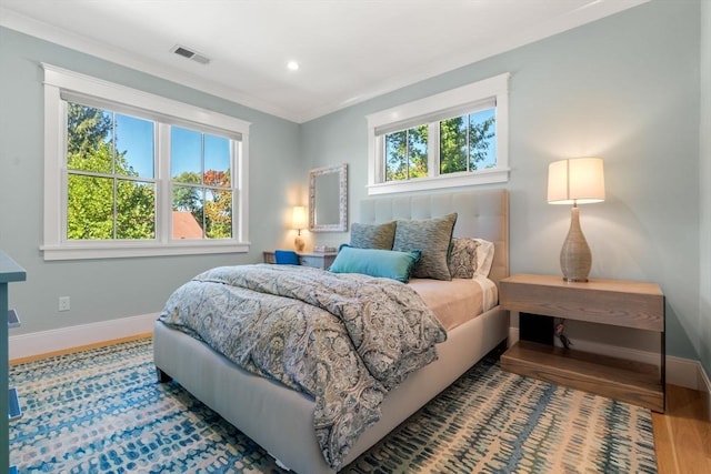 bedroom featuring recessed lighting, visible vents, ornamental molding, wood finished floors, and baseboards