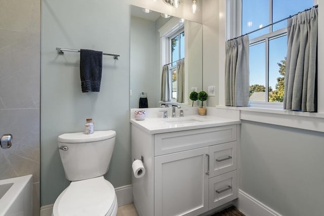 full bathroom featuring toilet, baseboards, and vanity