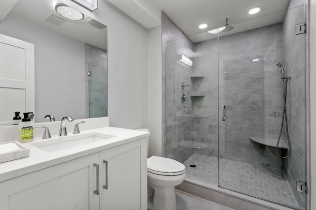 bathroom with a stall shower, visible vents, vanity, and toilet