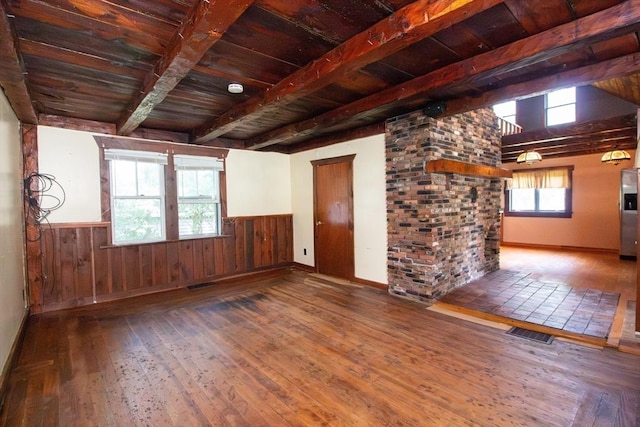 unfurnished room featuring hardwood / wood-style flooring, wood ceiling, wooden walls, and beamed ceiling