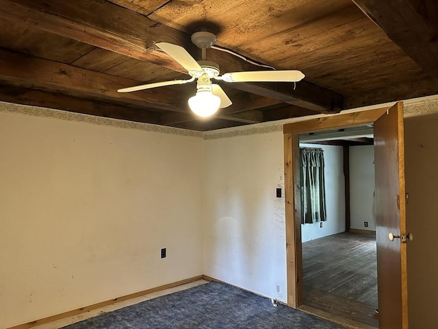 carpeted spare room featuring wood ceiling, a ceiling fan, and beamed ceiling