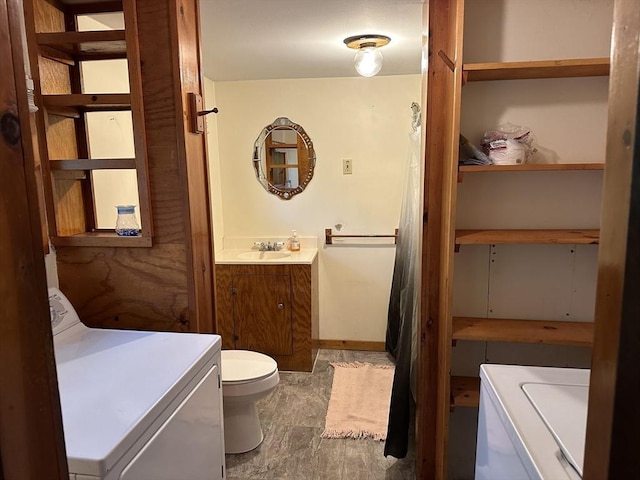 bathroom with toilet, washer / dryer, and vanity