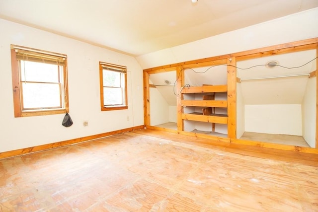 empty room with vaulted ceiling and baseboards