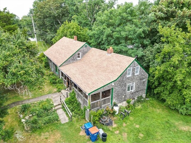 back of property featuring a porch and a lawn