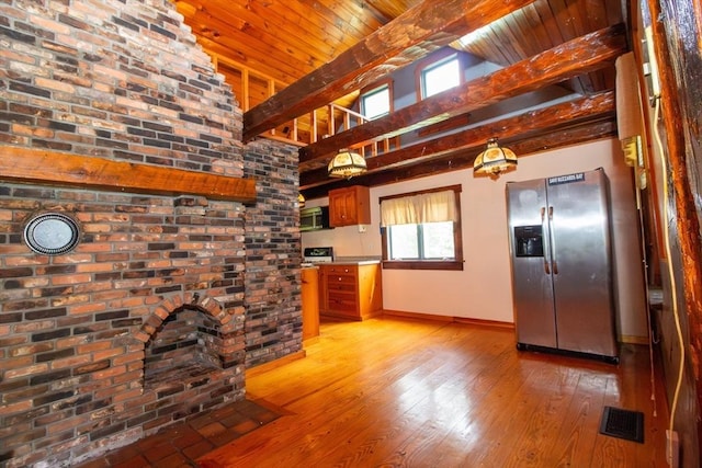 kitchen with visible vents, baseboards, light wood-style floors, appliances with stainless steel finishes, and beamed ceiling