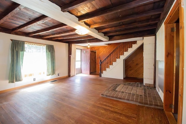 unfurnished living room with wooden ceiling, stairs, beam ceiling, and wood finished floors