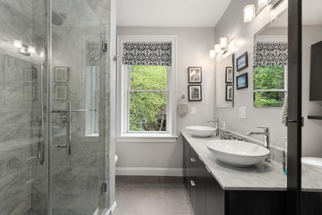 bathroom with baseboards, healthy amount of natural light, tile patterned flooring, and a shower stall