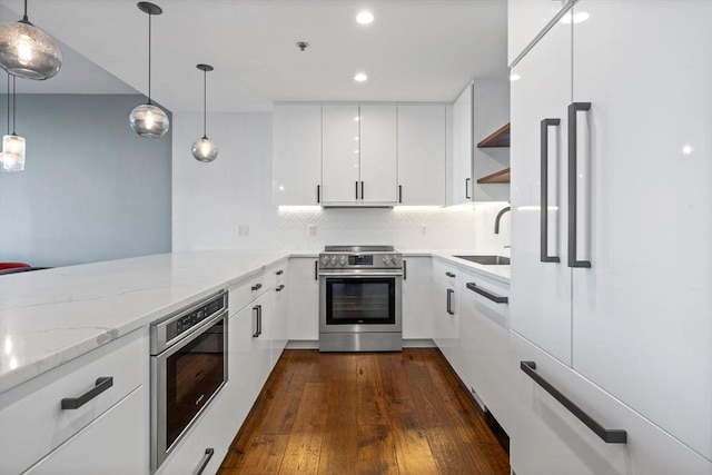 kitchen featuring electric stove, sink, pendant lighting, paneled built in fridge, and white cabinets