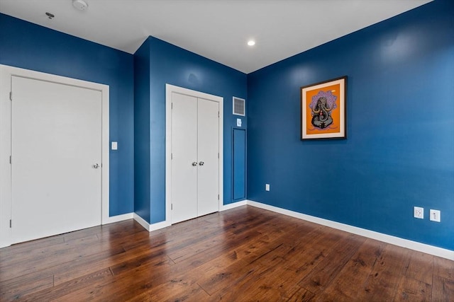 unfurnished bedroom featuring dark wood-type flooring and a closet