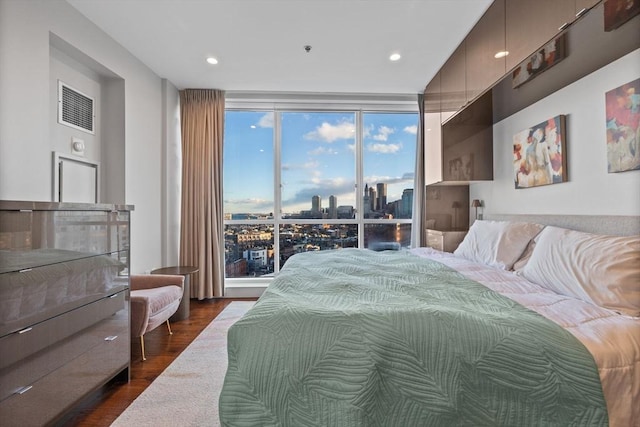 bedroom with floor to ceiling windows and dark hardwood / wood-style floors