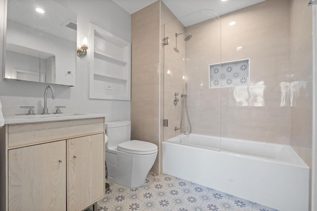 full bathroom featuring tiled shower / bath combo, vanity, and toilet