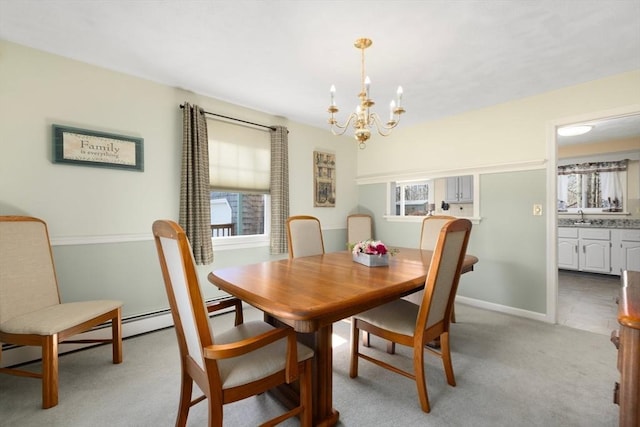 dining room featuring a notable chandelier, light colored carpet, and baseboards