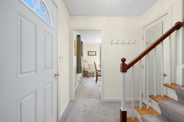 carpeted foyer entrance featuring stairway and baseboards