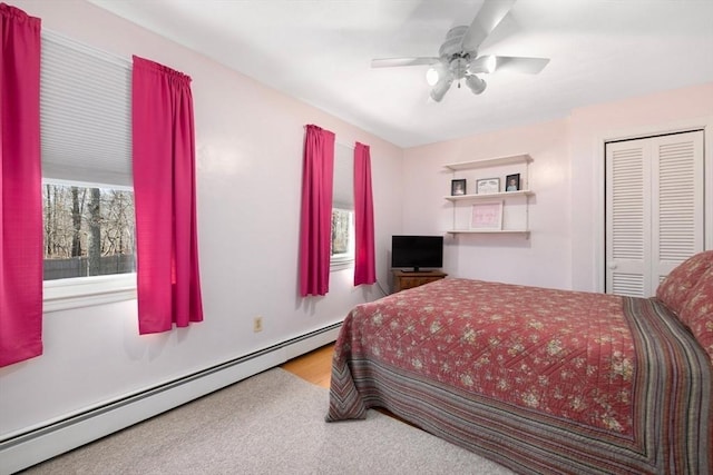 bedroom with a baseboard heating unit, a closet, and ceiling fan