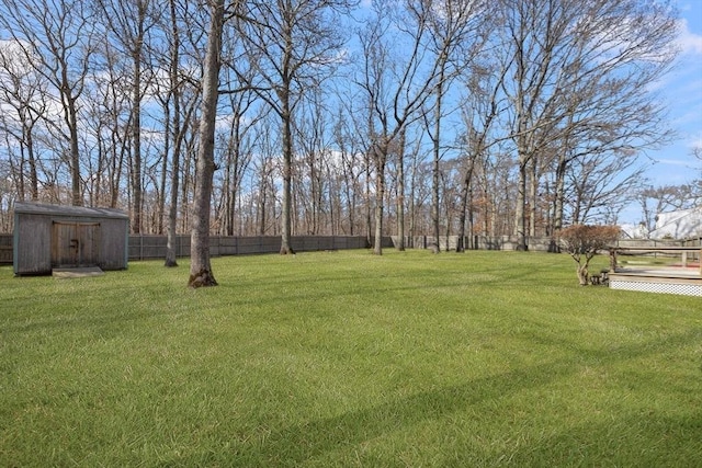 view of yard with a fenced backyard, a storage unit, and an outdoor structure