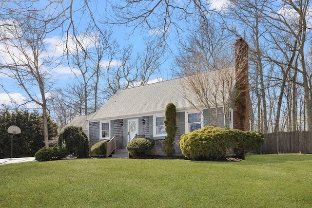 cape cod home featuring a chimney, a front yard, and roof with shingles