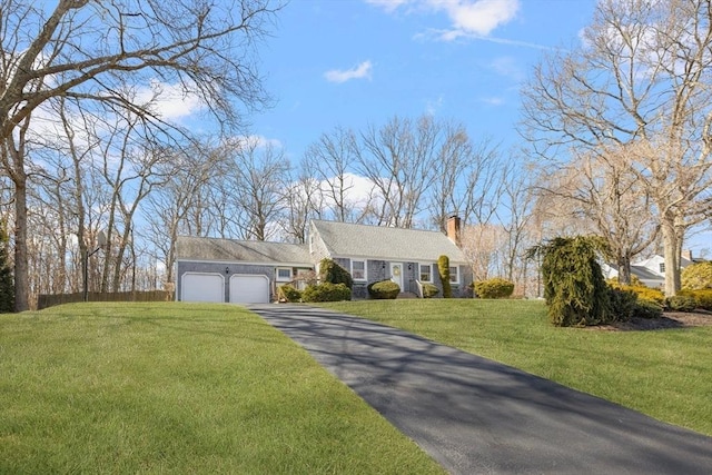 view of front facade with driveway, a chimney, a garage, and a front yard