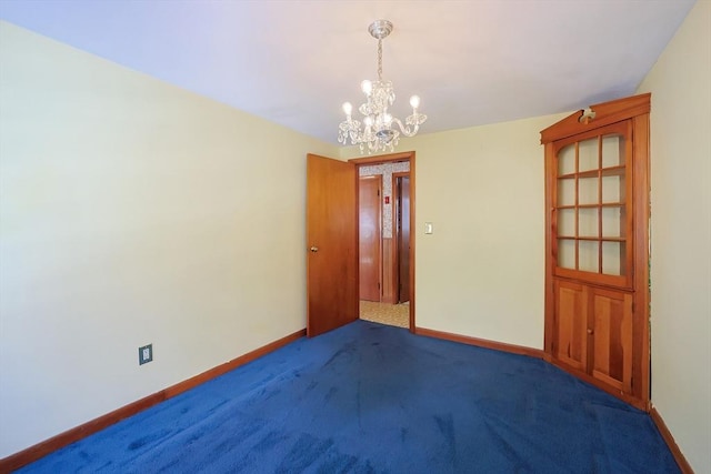 carpeted empty room featuring a notable chandelier