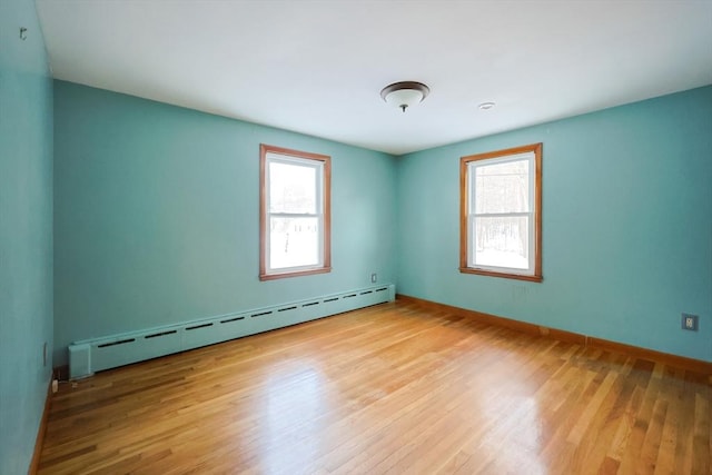 unfurnished room featuring light wood-type flooring and a baseboard radiator