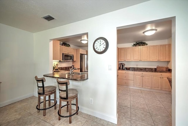 1656 Saint Clair Ave E, Fort Myers, FL 33903 - kitchen featuring sink, dark stone countertops, decorative backsplash, stainless steel appliances, and light brown cabinets