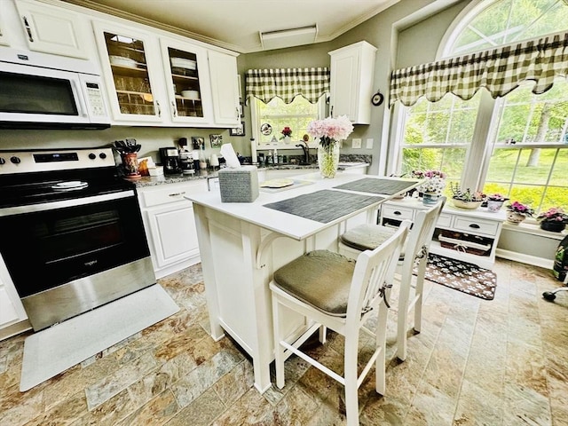 1408 Fox Run, Middleboro, MA 02346 - kitchen featuring white microwave, stainless steel electric stove, white cabinets, and healthy amount of natural light
