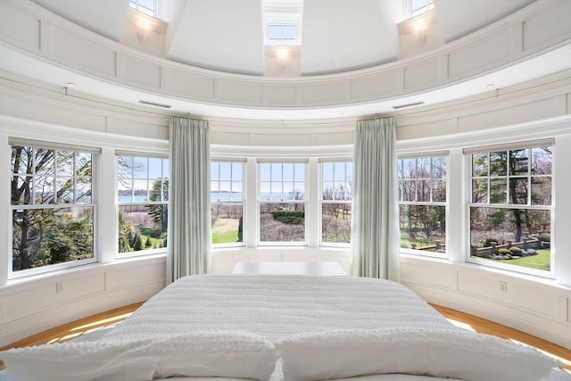 bedroom featuring light wood finished floors and a decorative wall