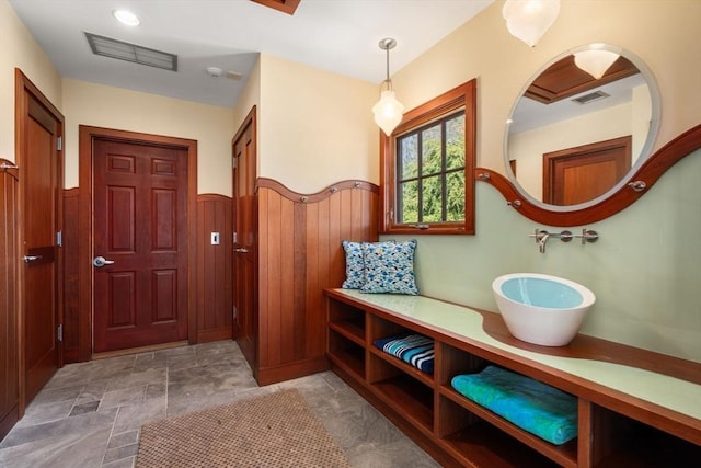 mudroom featuring wainscoting, wooden walls, and visible vents