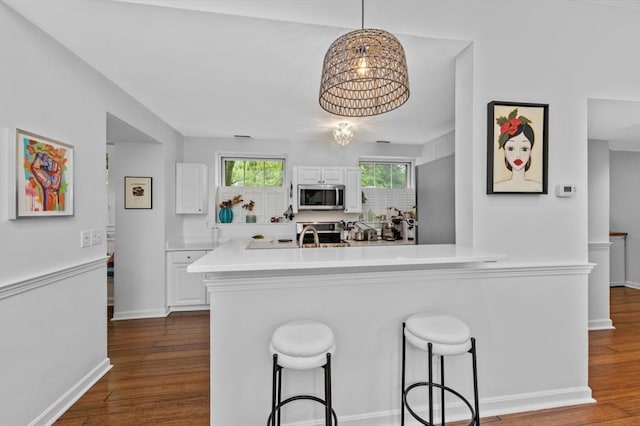 60 Glen Rd Unit 201, Brookline, MA 02445 - kitchen featuring appliances with stainless steel finishes, white cabinetry, a kitchen breakfast bar, and light countertops
