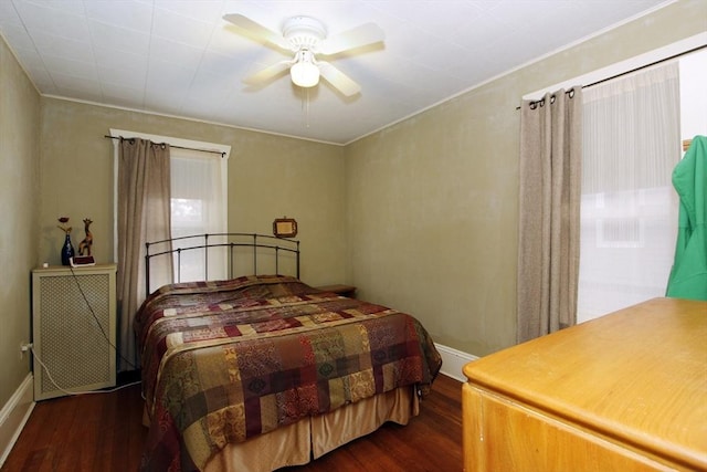 bedroom featuring ceiling fan, baseboards, and wood finished floors