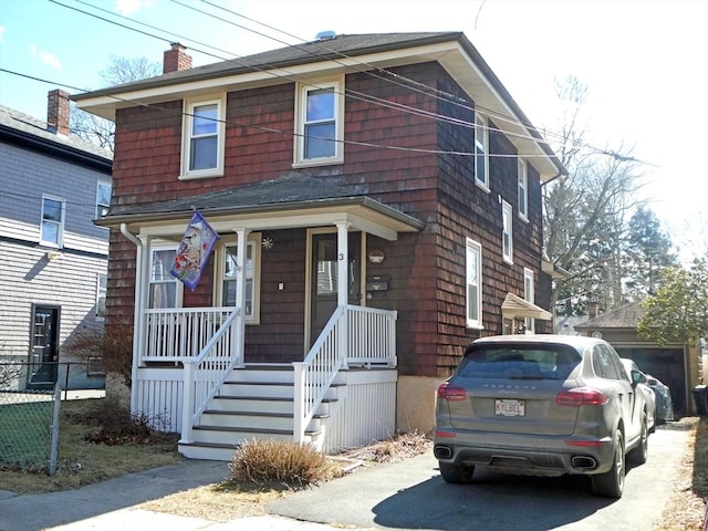 traditional style home with a porch, a chimney, and fence