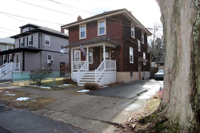 traditional style home featuring cooling unit, fence, driveway, covered porch, and a chimney