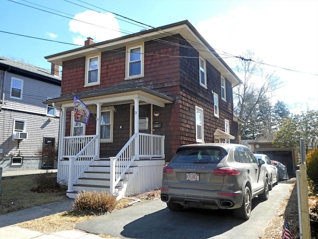 traditional style home featuring cooling unit, fence, covered porch, and a chimney