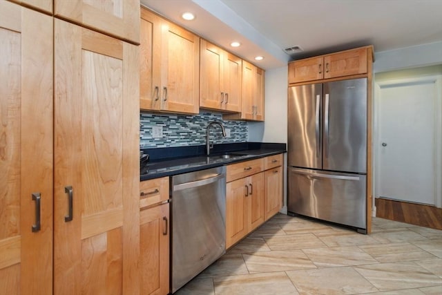 kitchen with appliances with stainless steel finishes, a sink, tasteful backsplash, and recessed lighting
