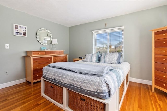 bedroom with wood finished floors and baseboards