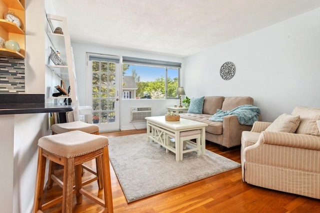 living area with wood finished floors and a wall mounted AC