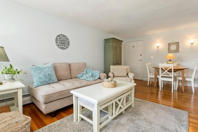living area featuring a baseboard heating unit and wood finished floors