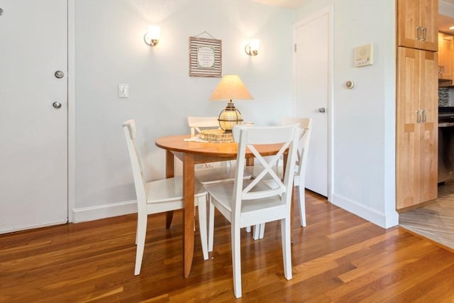 dining room featuring wood finished floors and baseboards