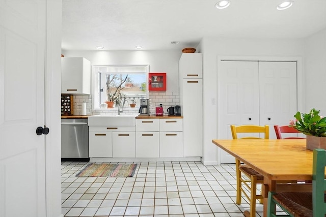 kitchen featuring white cabinetry, recessed lighting, dishwasher, a sink, and backsplash