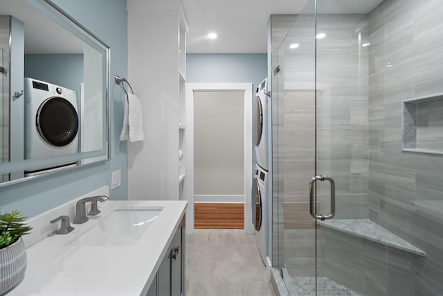full bathroom with recessed lighting, stacked washer and clothes dryer, a stall shower, and vanity