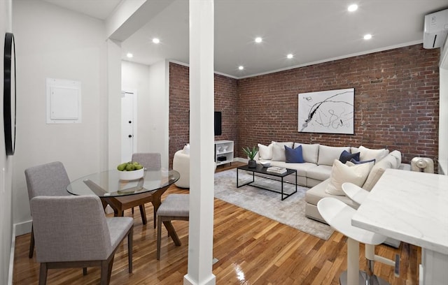 living area with light wood-type flooring, crown molding, brick wall, and recessed lighting