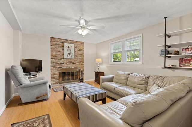 10 Lisa Ln, Reading, MA 01867 - living area with a ceiling fan, light wood finished floors, a fireplace, baseboards, and a textured ceiling