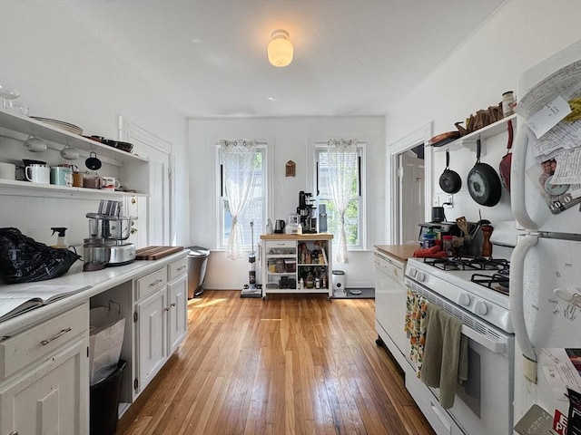 57 Bartlett St, Somerville, MA 02145 - kitchen with white appliances, open shelves, light wood finished floors, and light countertops
