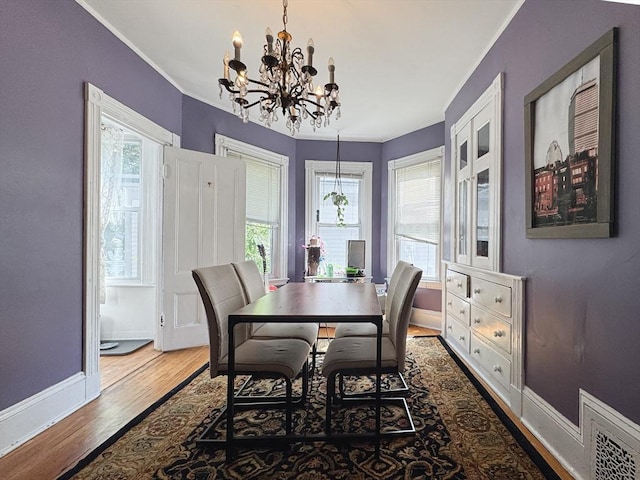 57 Bartlett St, Somerville, MA 02145 - dining area featuring a chandelier, wood finished floors, healthy amount of natural light, and ornamental molding
