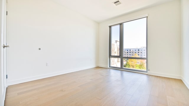 unfurnished room featuring light hardwood / wood-style flooring and plenty of natural light