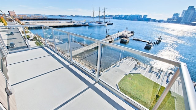 dock area with a water view and a balcony