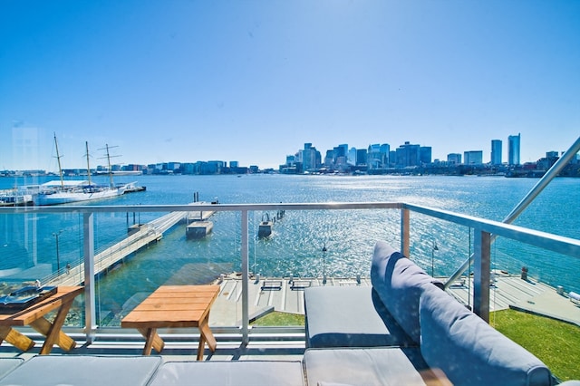 balcony with a water view and a dock