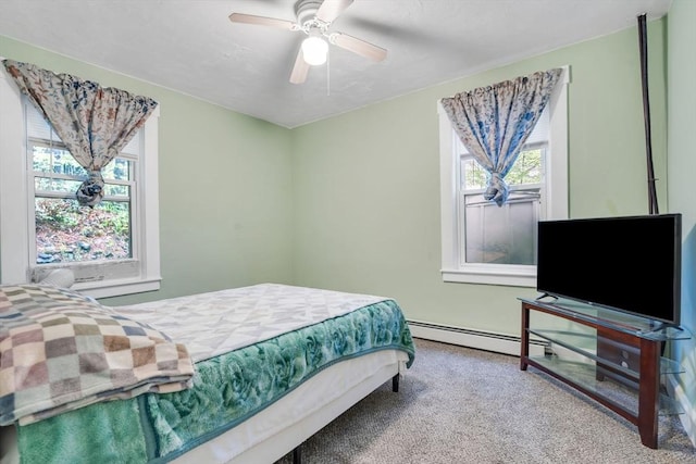 carpeted bedroom with a ceiling fan and a baseboard heating unit