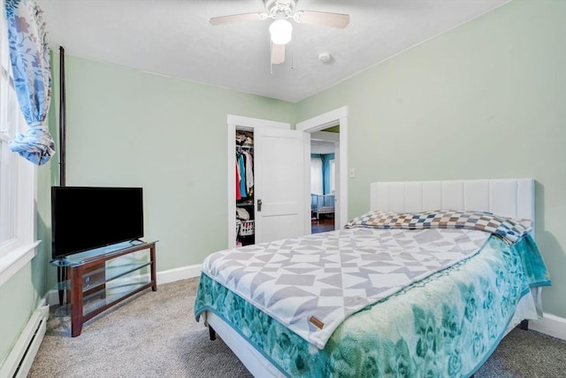 carpeted bedroom with a baseboard heating unit, baseboards, a closet, and a ceiling fan