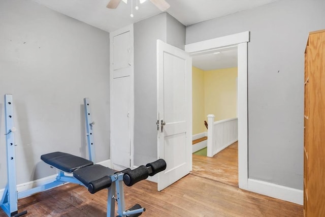 exercise area with wood finished floors, baseboards, and ceiling fan