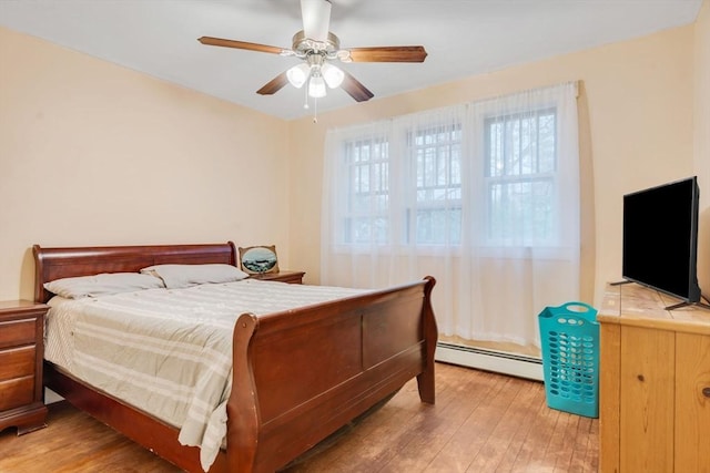 bedroom featuring light wood finished floors, a baseboard radiator, and ceiling fan